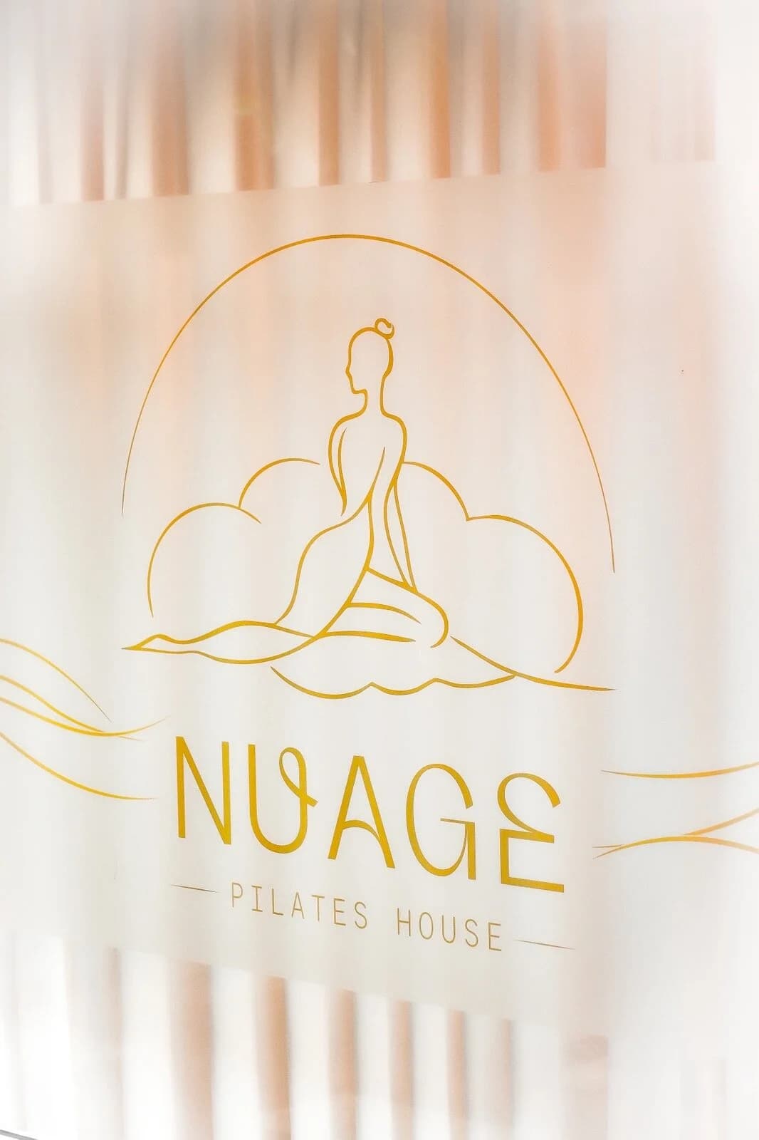 Логото на NUAGE — жена на облак — върху ефирен воал